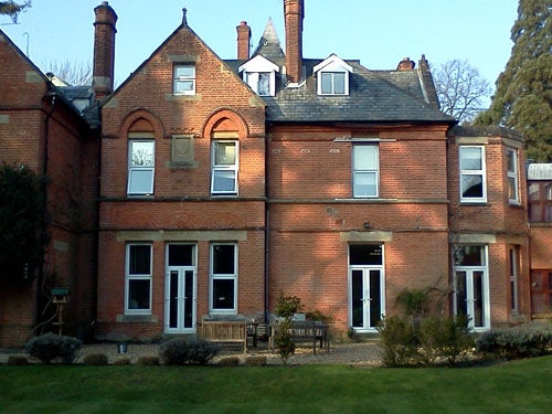 Photo of a red brick house with green lawn.