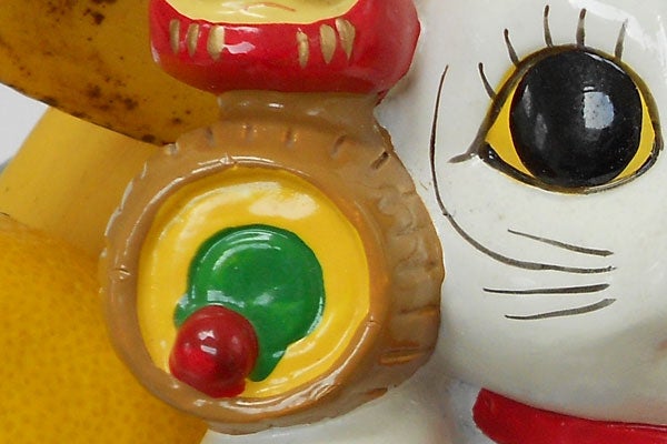 Close-up of colorful toy with a banana and apple in background.