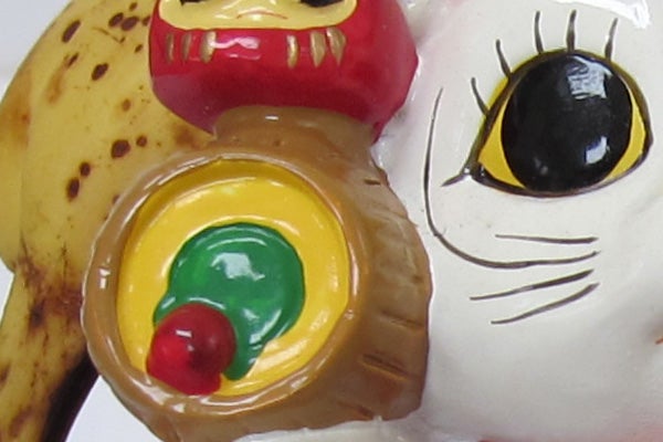 Close-up of colorful figurine next to a banana.
