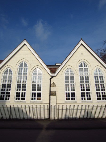 Photo of a white building with arched windows against blue sky.