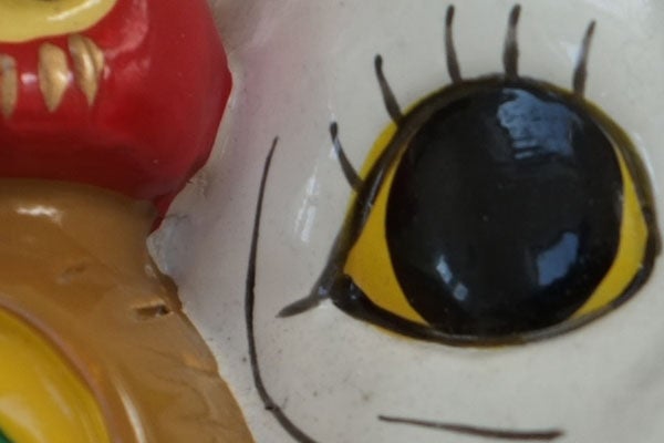 Close-up of colorful figurine eye detail.