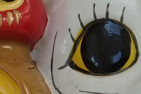 Close-up of a ceramic figurine's painted eye detail.