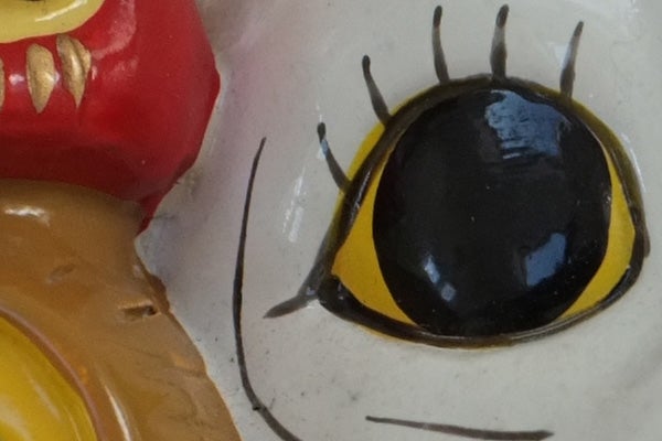 Close-up of a ceramic figurine's eye detail.