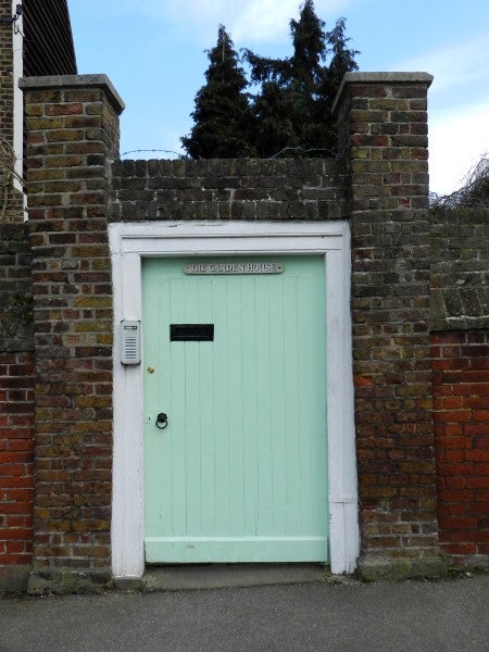 Light green door within brick wall, taken with Nikon Coolpix P500.