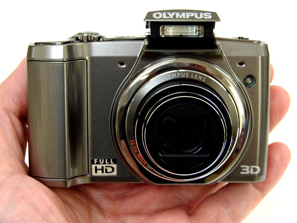 Olympus SZ-20 camera held in hand displaying lens and controls.