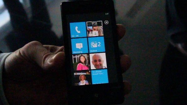 Hand holding a Windows Phone 7 with Mango update.