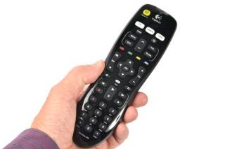Hand holding Logitech Harmony 200 universal remote control.