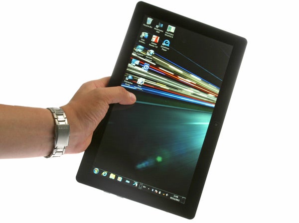 Hand holding a Samsung Series 7 Slate 700T displaying desktop screen.