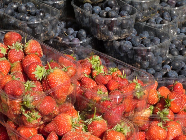 Close-up photo of strawberries and blueberries in plastic containers.