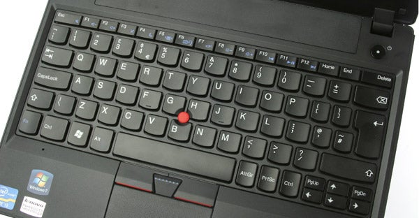 Lenovo ThinkPad X121e laptop with open screen displaying wallpaper.Lenovo ThinkPad X121e laptop with open lid on white background.Close-up of Lenovo ThinkPad X121e trackpad and red TrackPoint.Close-up of Lenovo ThinkPad X121e keyboard and trackpoint