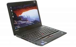 Lenovo ThinkPad X121e laptop with open screen displaying wallpaper.