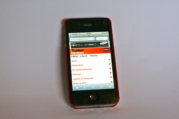 iPhone in red Otterbox Commuter case displaying a review website.