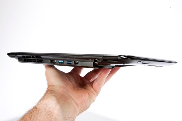 Hand holding thin Acer Aspire S5 laptop showcasing ports