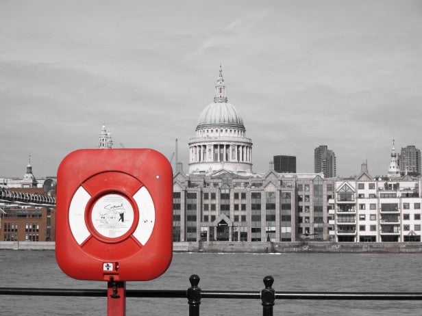Red lifebuoy on railing with St. Paul's Cathedral in background