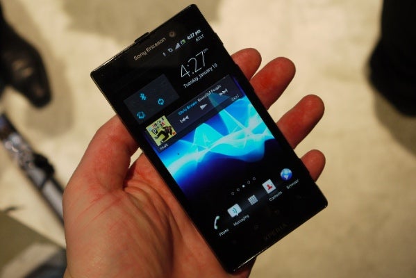 Sony Xperia Ion smartphone held in hand displaying home screen.