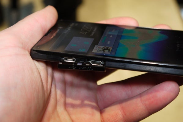Hand holding a Sony Xperia Ion smartphone showing side ports.