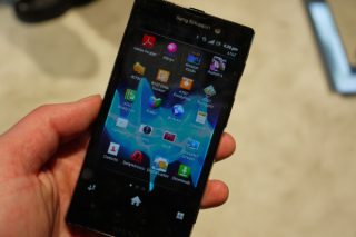 Hand holding a Sony Xperia Ion displaying apps on screen.