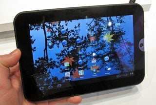 Hand holding Toshiba Thrive 7 tablet displaying home screen.