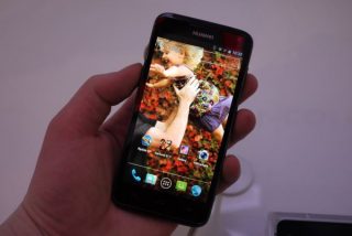 Hand holding a Huawei Ascend D Quad smartphone.
