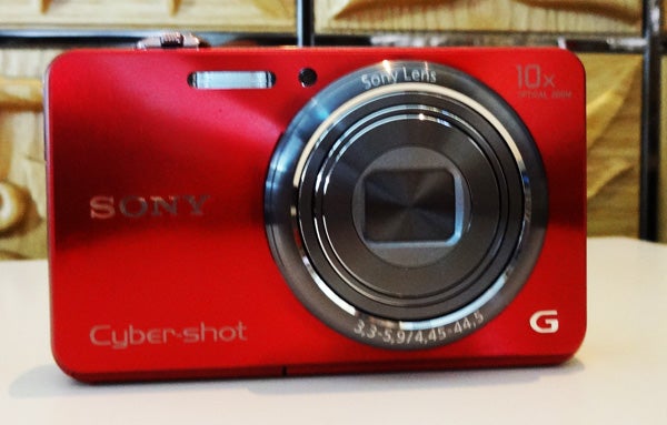 Red Sony Cyber-shot DSC-WX100 digital camera on a table.