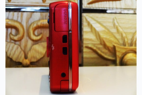 Side view of red Sony Cyber-shot WX100 camera.