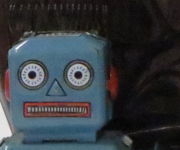 Vintage blue toy robot face close-up.