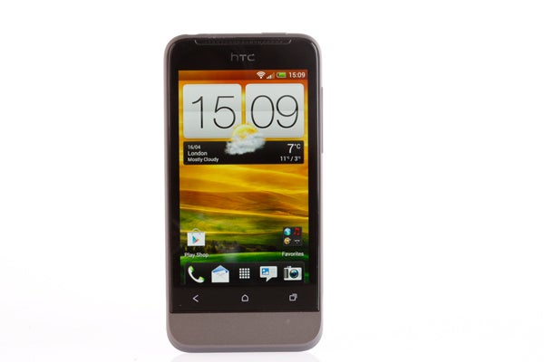 HTC One V smartphone displaying time and weather on screen.