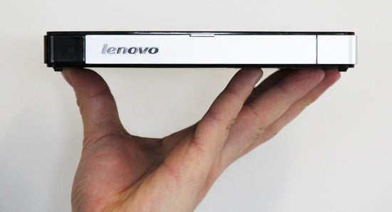 Hand holding a Lenovo IdeaCentre Q180 mini desktop.