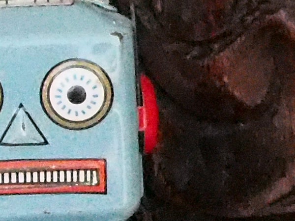 Close-up of a vintage toy robot against a textured background.