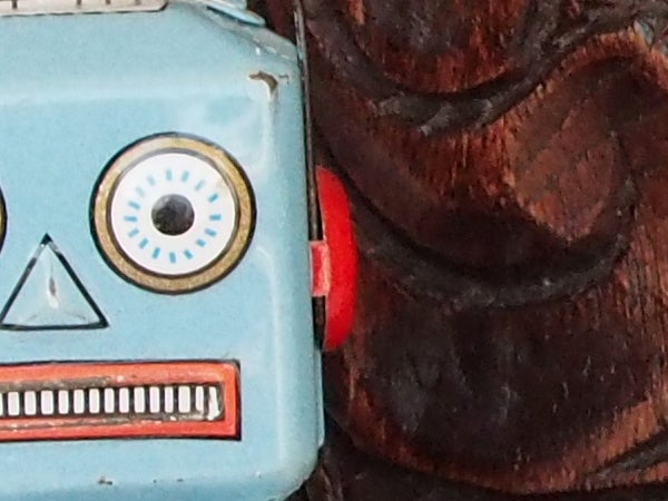 Close-up of a vintage toy robot and a wooden mask.
