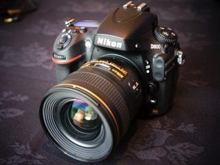 Nikon D800 DSLR camera with lens on table.