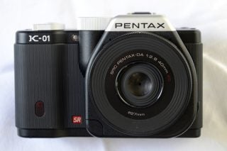 Pentax K-01 camera with DA 40mm lens on white background