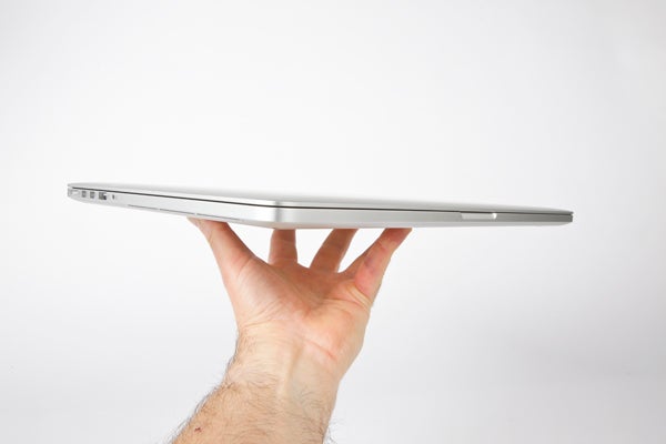 Hand holding a thin Apple MacBook Pro 15-inch side view.
