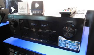Denon AVR-2113 receiver displayed at an electronics exhibit.