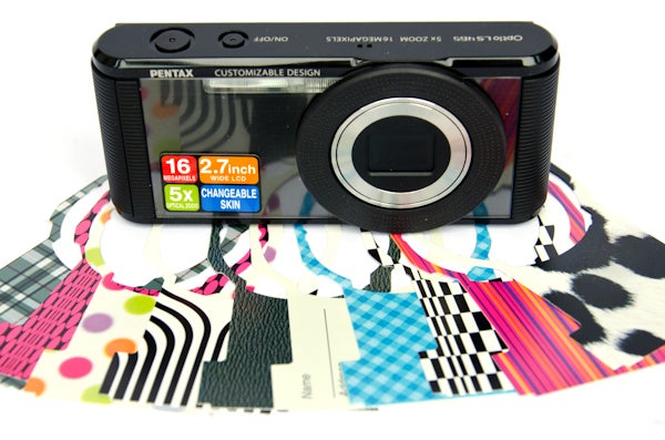 Pentax Optio LS465 camera with colorful skins on patterned background.