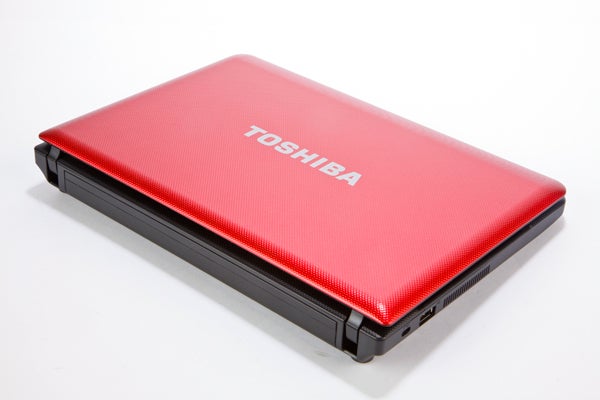 Red Toshiba NB510 netbook closed on white background.