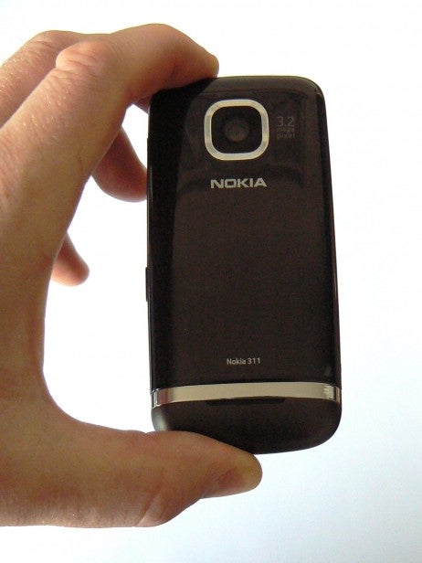 Hand holding a Nokia Asha 311 mobile phone.