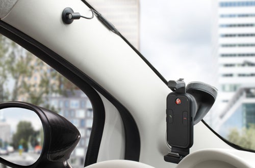 TomTom hands-free car kit mounted on vehicle window.