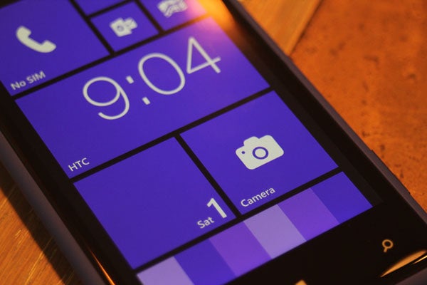 Close-up of HTC 8X smartphone screen displaying time and camera icon.