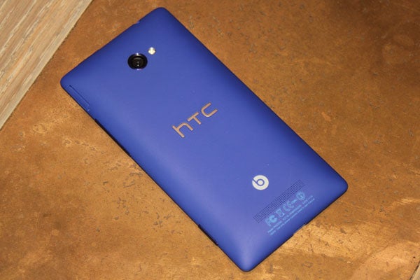 Blue HTC 8X smartphone on wooden surface.