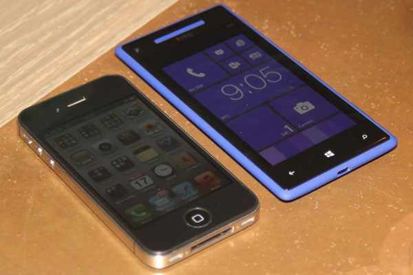 HTC 8X smartphone next to an iPhone on a table.