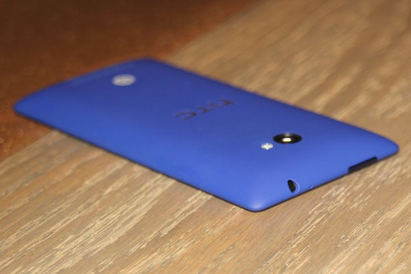 Blue HTC 8X smartphone on wooden surface.