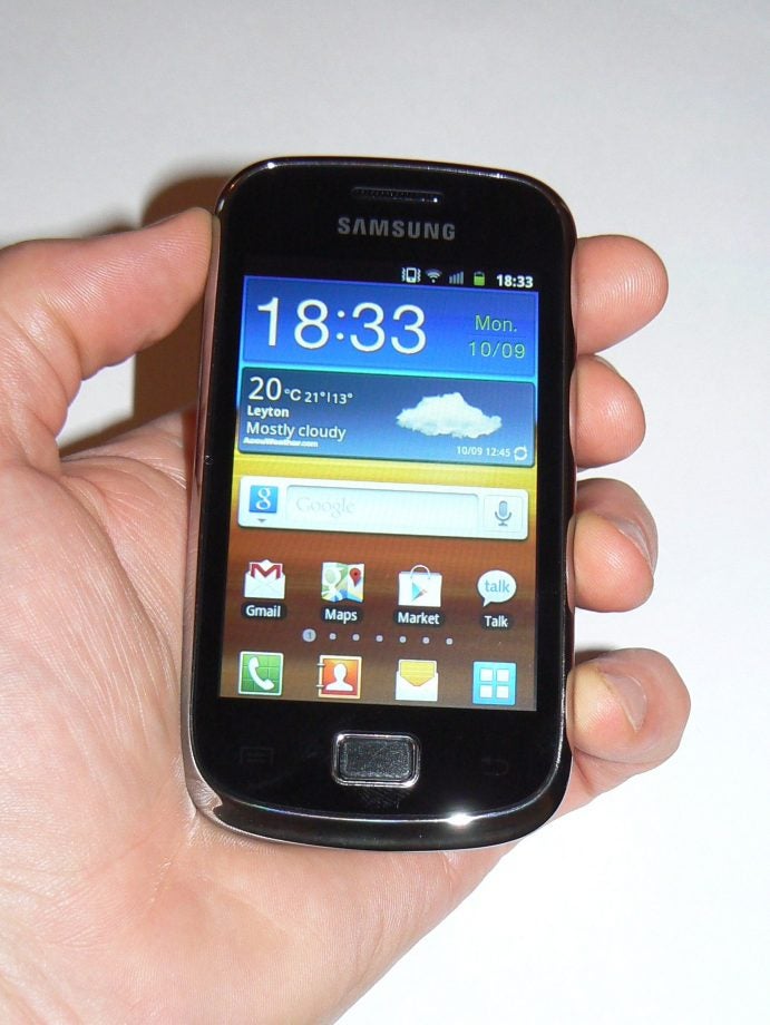Samsung Galaxy Mini 2 smartphone held in hand displaying home screen.