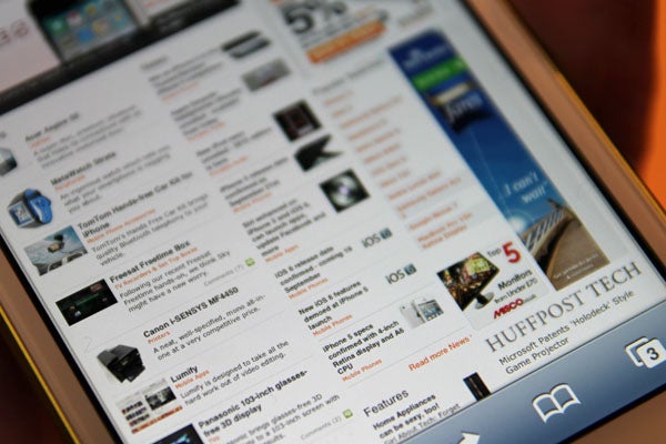 Close-up of iPhone 5 displaying news website.
