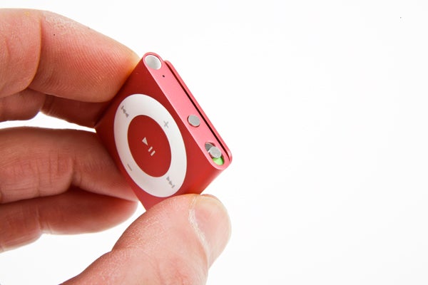 Hand holding a red iPod shuffle from 2012.