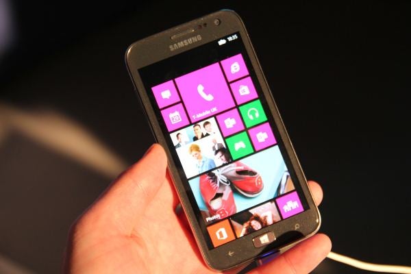 Hand holding Samsung Ativ S displaying colorful tiles on screen.