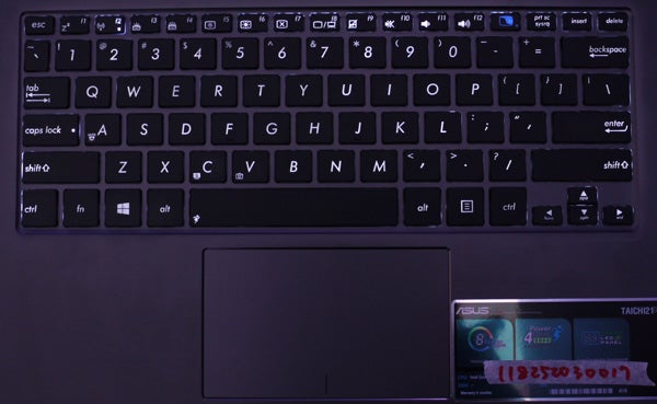Asus Taichi laptop keyboard with dual-screen feature visible.