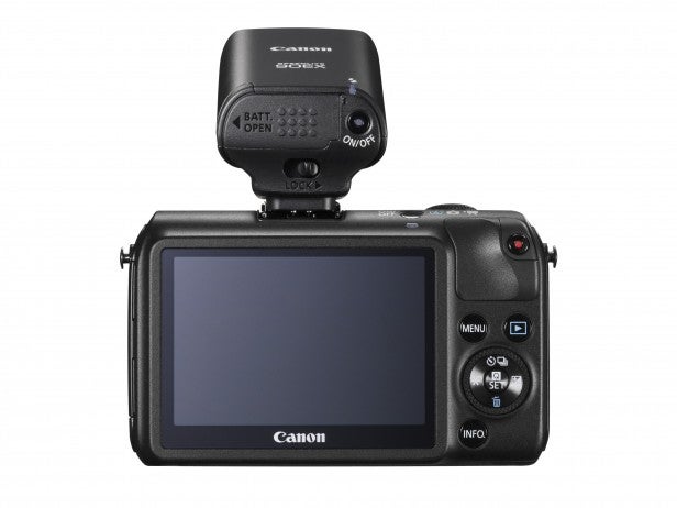 Canon EOS M camera with flip screen and external microphone attached.