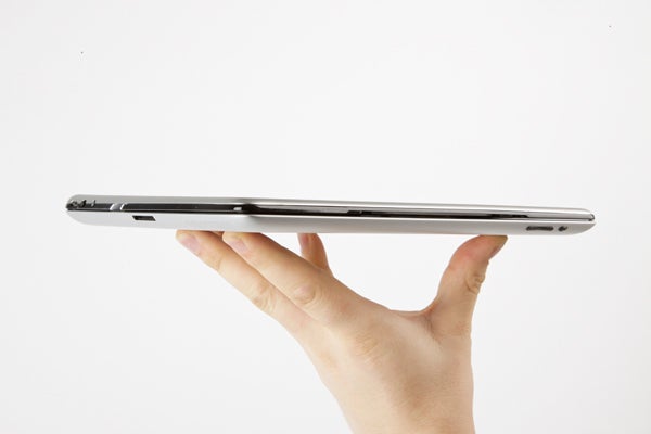 Hand holding a slim Logitech keyboard cover with an iPad attached.