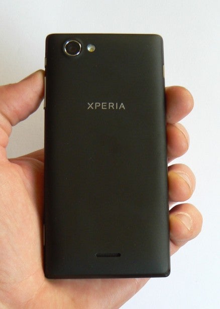 Hand holding a black Sony Xperia J smartphone.